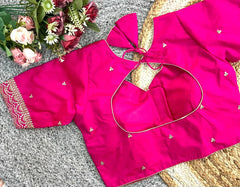 Pink blouse with floral decorations on a textured surface