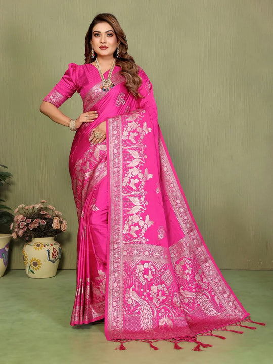 Woman wearing a pink saree with white floral patterns on a green background