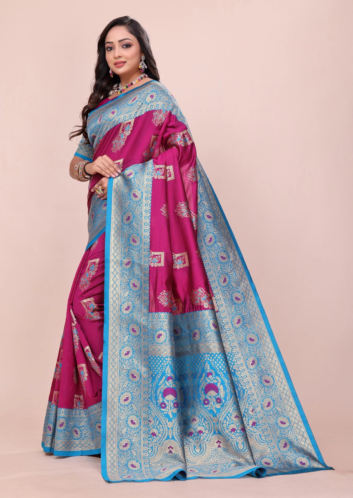 Woman wearing a pink and blue saree with a beige background