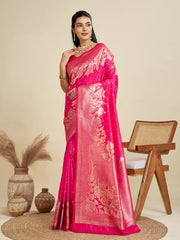 Woman wearing a pink saree with gold embroidery in a minimalistic setting.