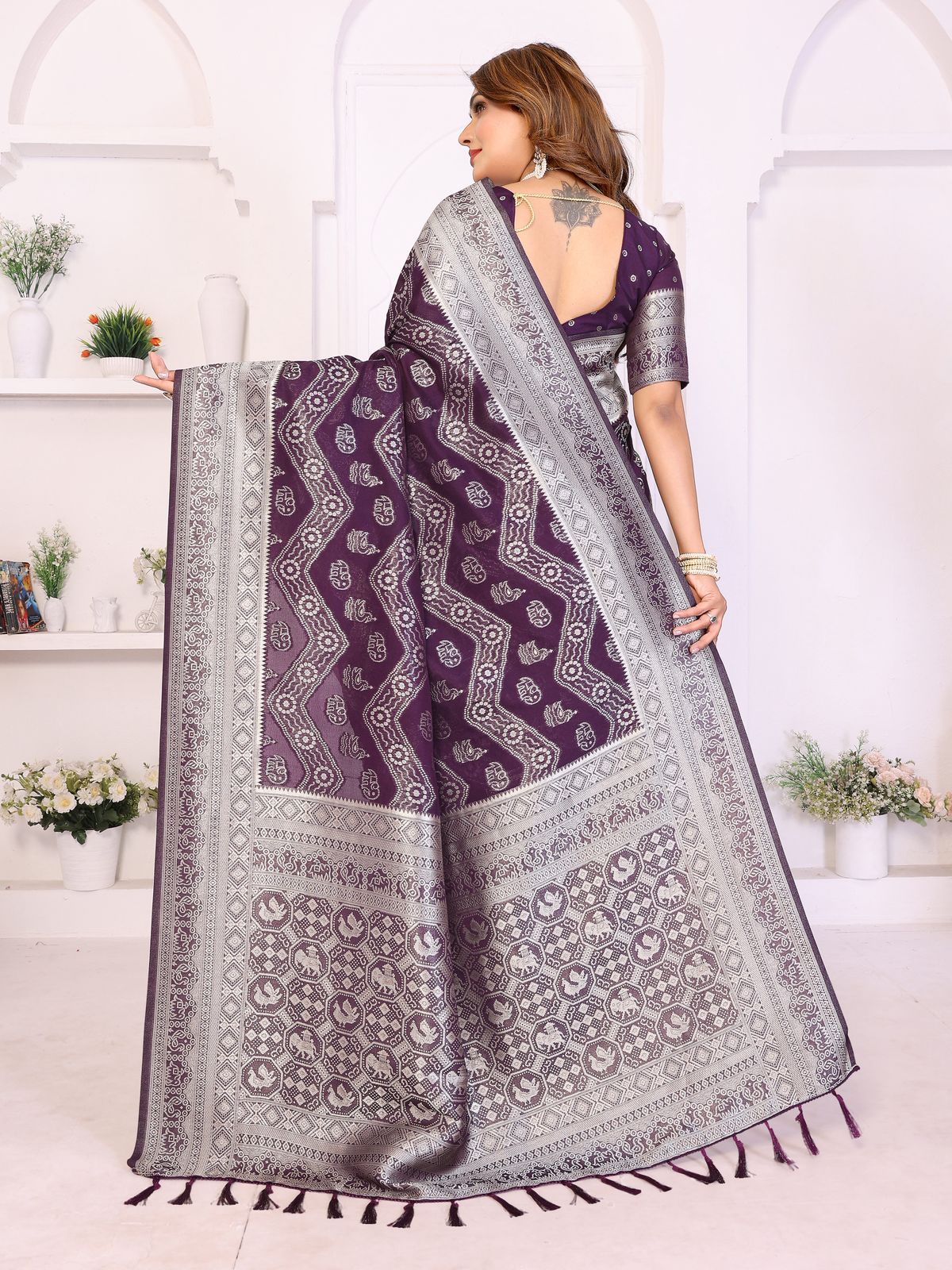 Woman wearing a purple and gray saree with a white background