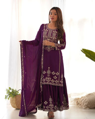 Woman wearing a purple embroidered traditional outfit with a white background