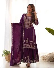 Woman wearing a purple embroidered traditional outfit with a white background