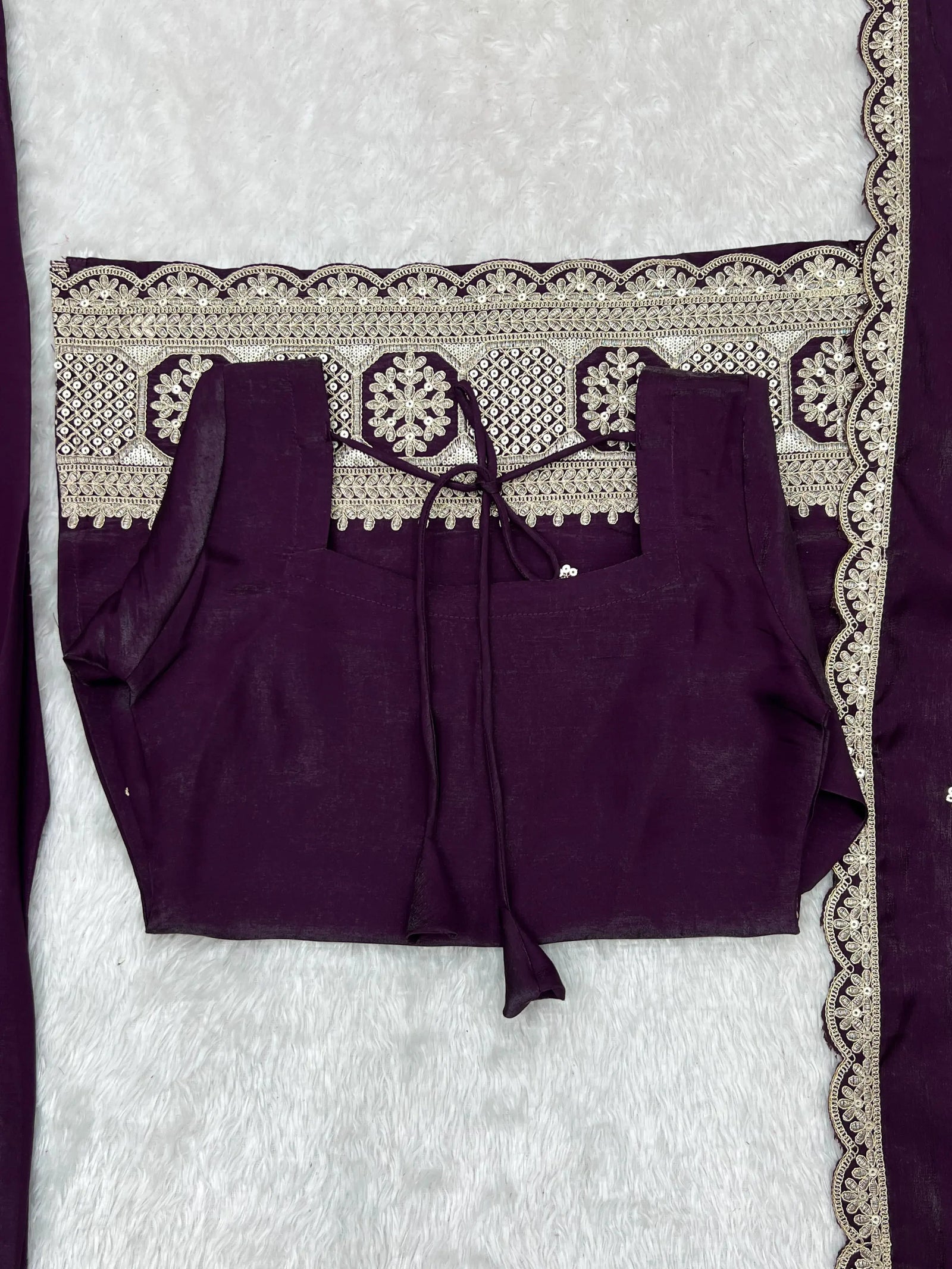 A woman models a rich plum ethnic outfit featuring elegant silver embroidered details.