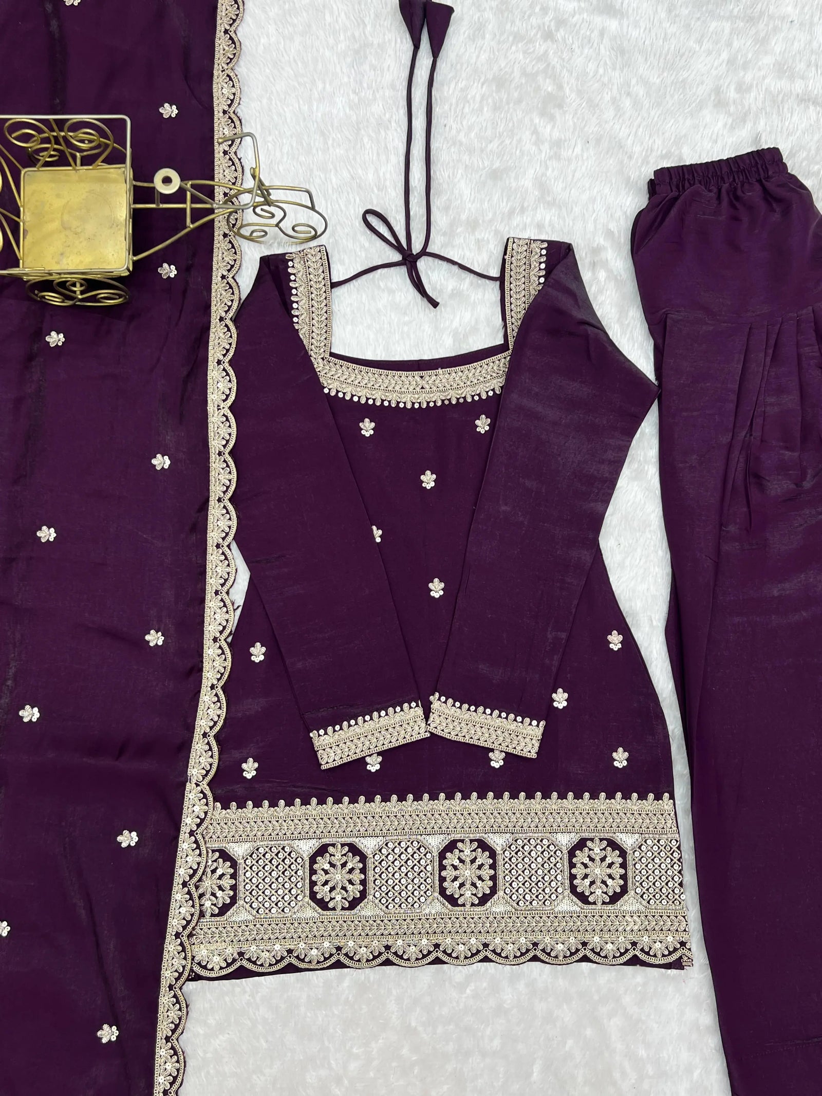 Purple traditional outfit with white embroidery on a textured surface