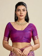 Woman wearing a purple blouse with gold details on a beige background