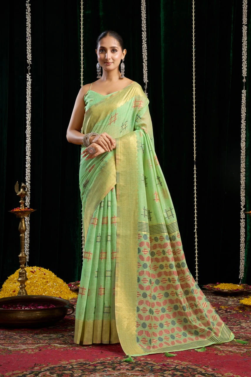 Woman wearing a light green saree with a floral pattern on a dark background