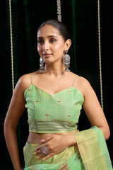 Woman wearing a green saree with a black background