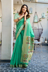 Woman wearing a green saree with floral patterns in an outdoor setting
