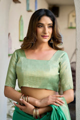 Woman wearing a green traditional outfit with a blurred background