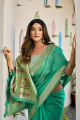 Woman wearing a green saree with floral patterns in an indoor setting