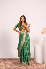 Woman wearing a green saree with gold patterns on a white background