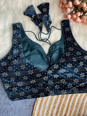 Blue floral-patterned sports bra and leggings set on a textured surface with flowers.