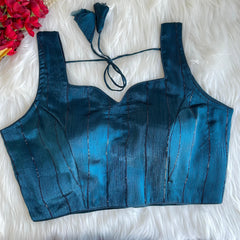 Blue top on a white fluffy surface with floral decorations