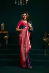 Woman in a red and blue saree standing on a dark staircase.
