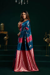 Woman wearing a blue and red saree with a dark background