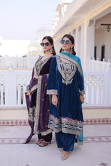 Two women in traditional outfits standing on a balcony with a white railing.