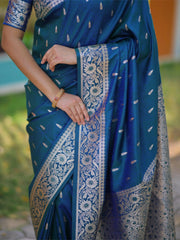 Blue saree with white patterns held by a person outdoors