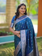 Woman wearing a blue saree with a patterned border outdoors
