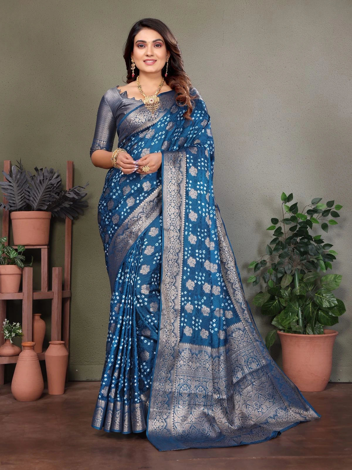 Woman wearing a blue saree with a patterned border indoors.