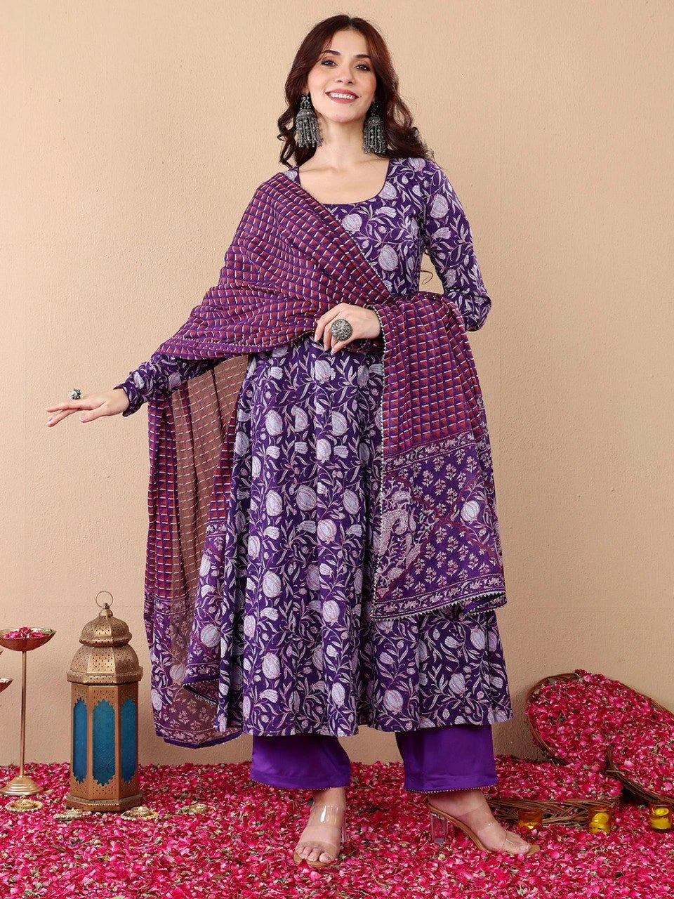 Woman wearing a purple patterned outfit on a beige background