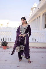 Woman in a purple traditional outfit standing on a balcony with white railing and decorative tiles.