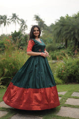 Woman in a green and red dress standing in a garden