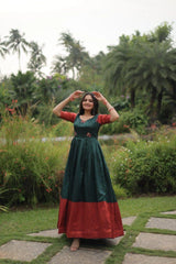 Woman in a green and red dress standing in a garden