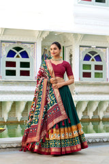 Woman in traditional multicolored lehenga standing in front of a decorative building with windows.