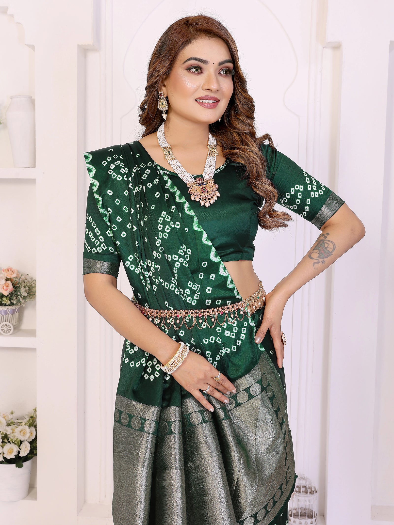 Woman wearing a green and gray traditional outfit with jewelry against a white background
