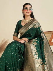 Woman wearing a green saree with gold patterns against a beige background