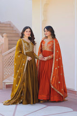 Two women in traditional embroidered dresses standing in a decorative interior setting.