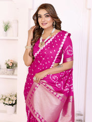 Woman wearing a pink saree with white patterns in a well-lit room.