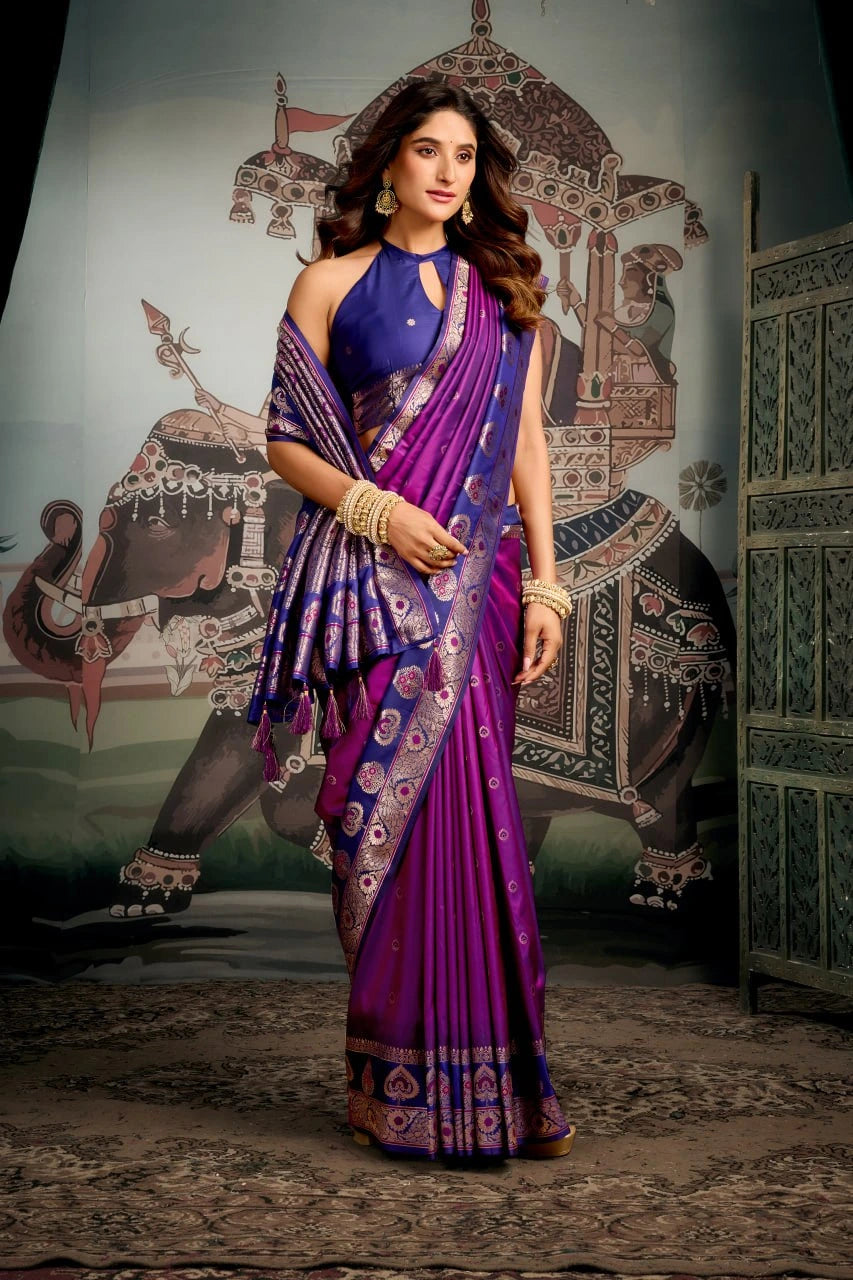 Woman in a purple saree standing in front of an elephant painting