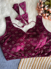 Purple floral-patterned lingerie set on a textured surface with flowers in the background