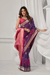Woman wearing a purple and pink saree with a white curtain background