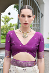 Traditional Banarasi silk saree in deep purple with ornate zari patterns draped gracefully.