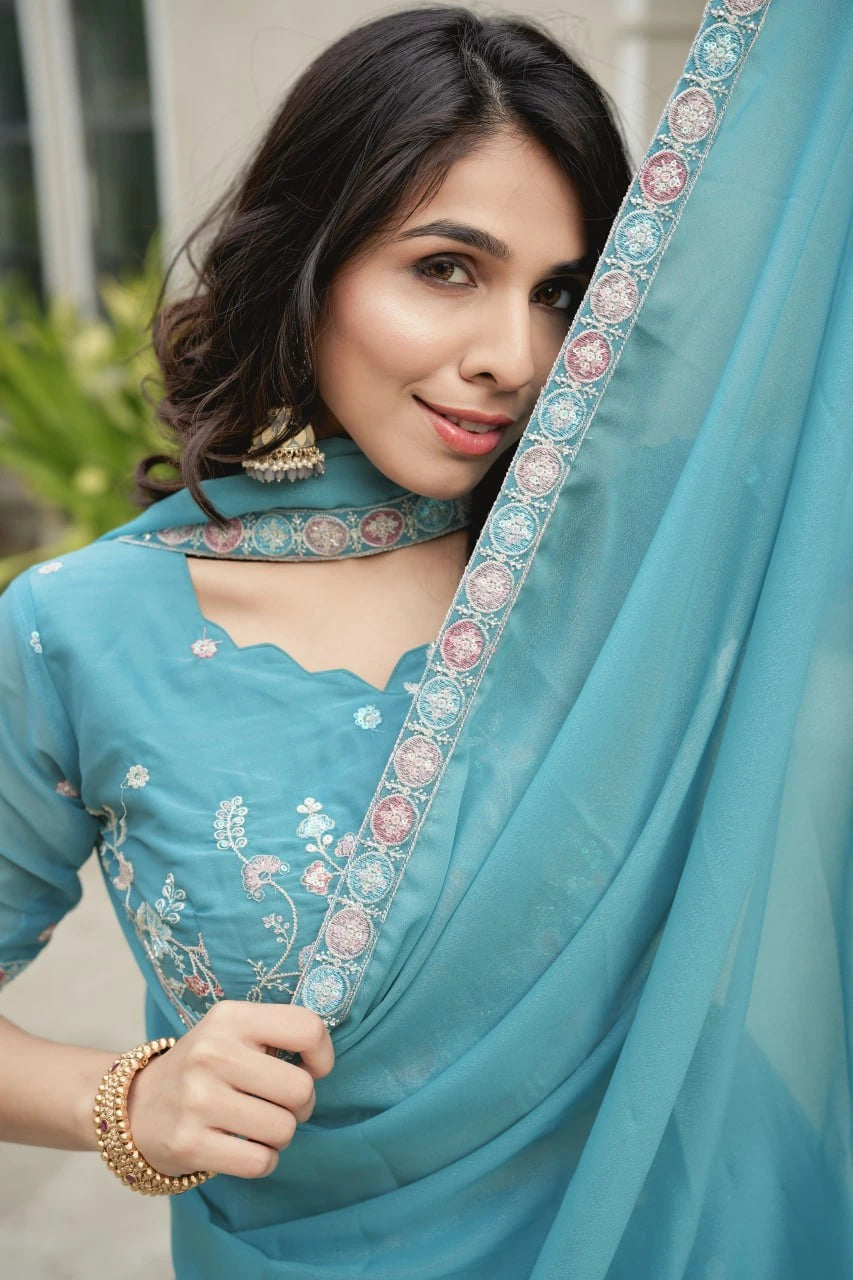 Woman wearing a blue embroidered saree with a blurred background
