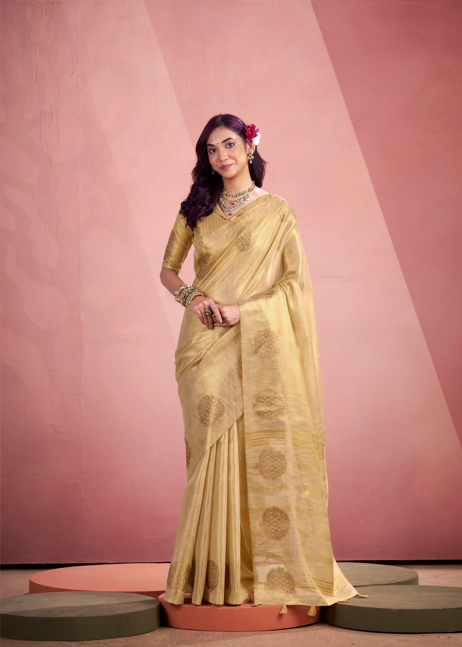 Woman in a yellow saree with a pink background