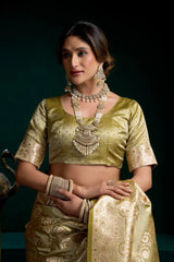 Woman wearing a traditional gold saree with jewelry against a dark background