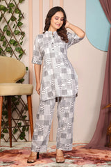 Woman wearing a patterned outfit standing in a room with decorative elements.