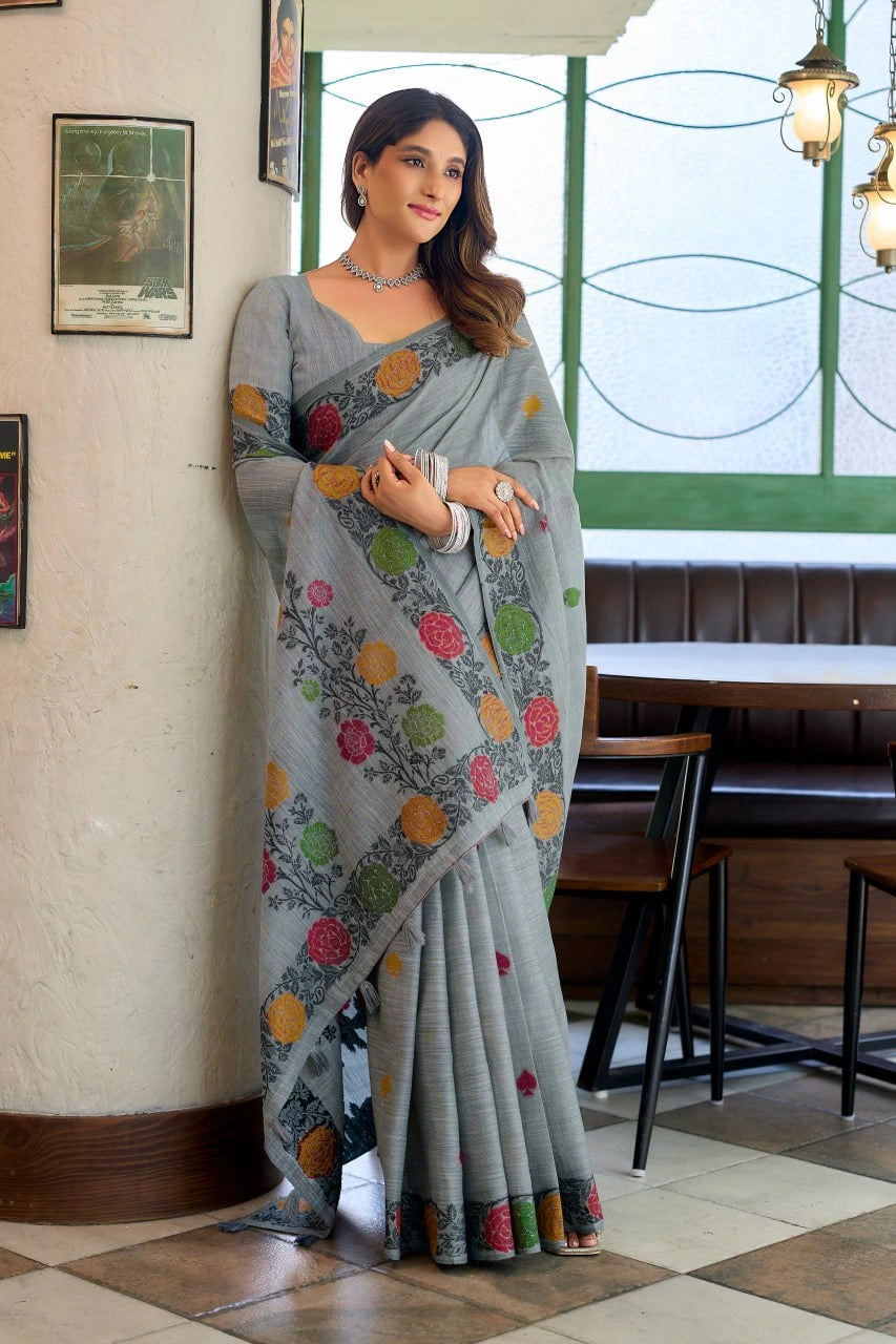 Woman wearing a gray saree with colorful patterns in an indoor setting.