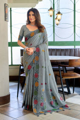 Woman in a gray saree with floral patterns in an indoor setting