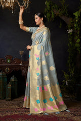 Woman in a traditional outfit with floral patterns standing in a decorated room.