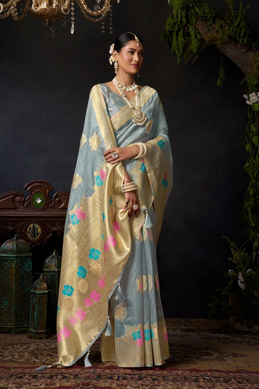 Woman in a traditional saree with floral patterns against a dark background