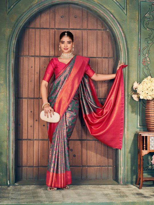 Woman in a traditional saree standing in front of a wooden door