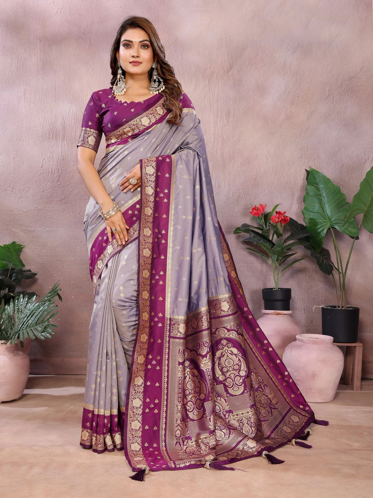 Woman wearing a gray and purple saree with floral decorations in the background