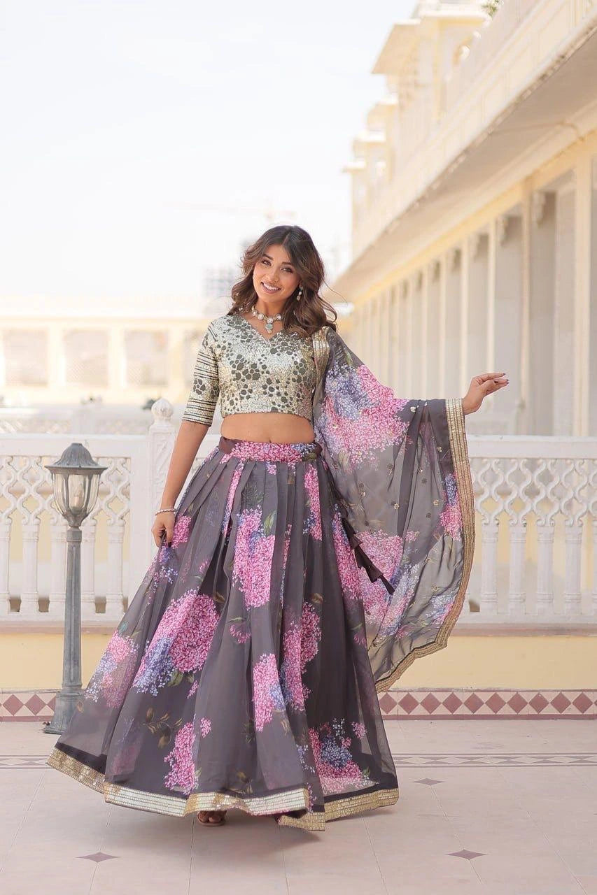 Woman in a traditional outfit with a floral design standing in front of a building.