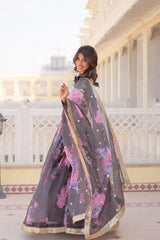 Woman wearing a floral saree in front of a white building with columns