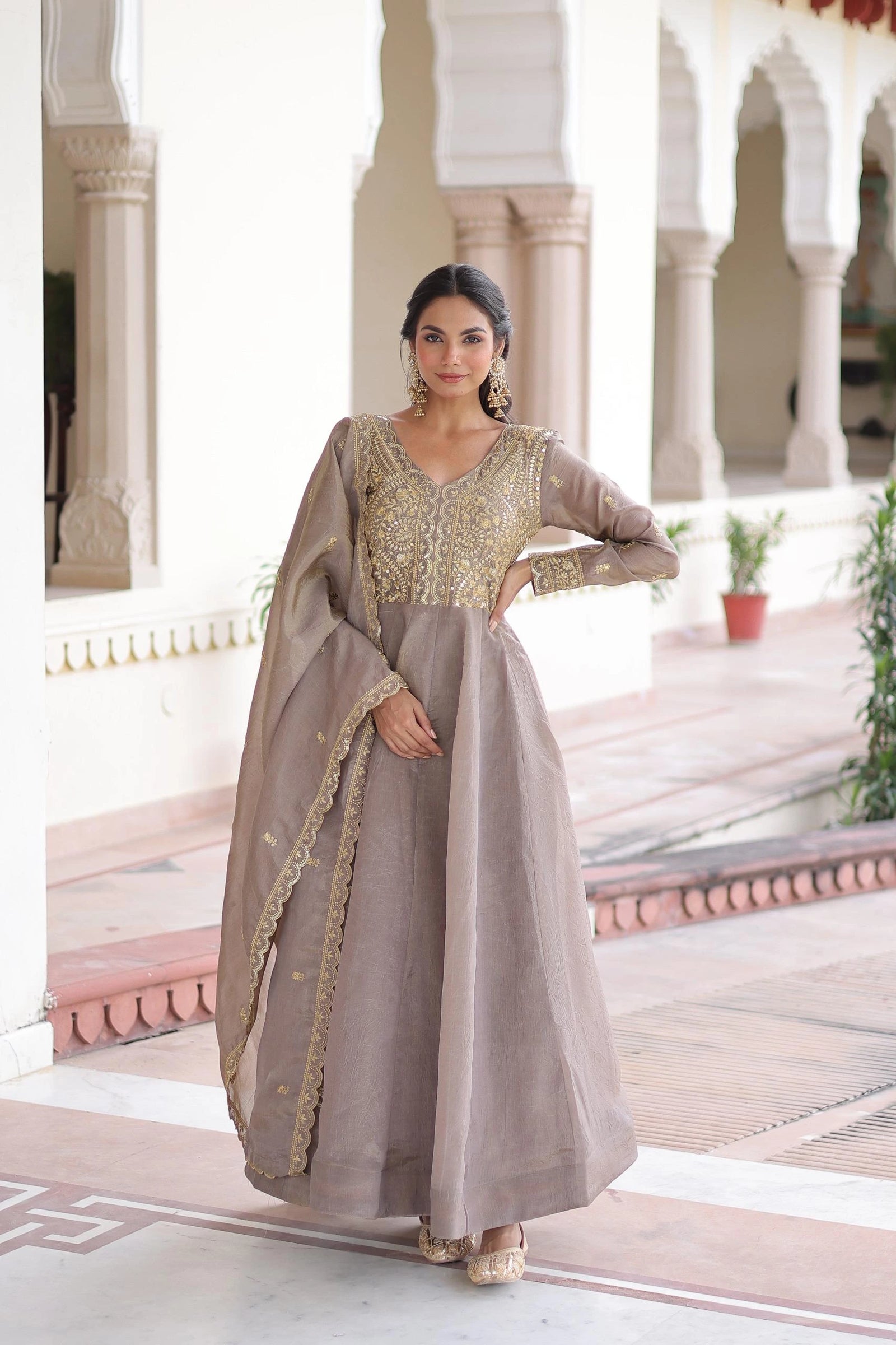 Woman in a traditional outfit standing in an architectural setting